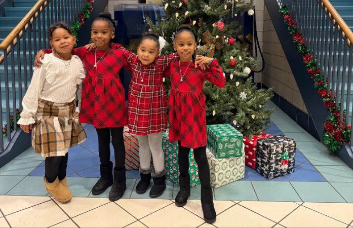  students pose in front of the holiday display